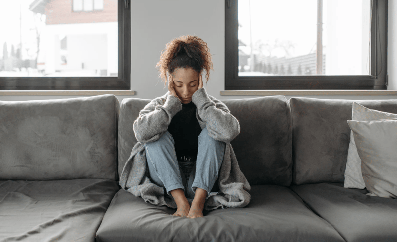 Woman appearing fatigued and distressed, reflecting symptoms of hormonal imbalance and inflammation.