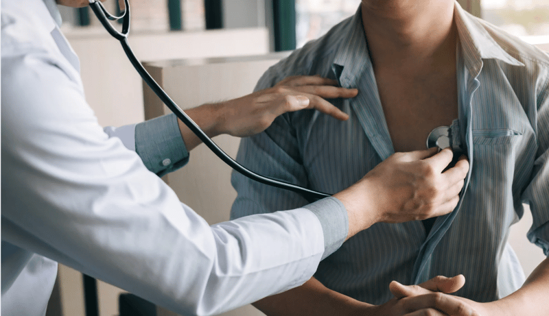 Doctor using a stethoscope to examine a patients heart health.