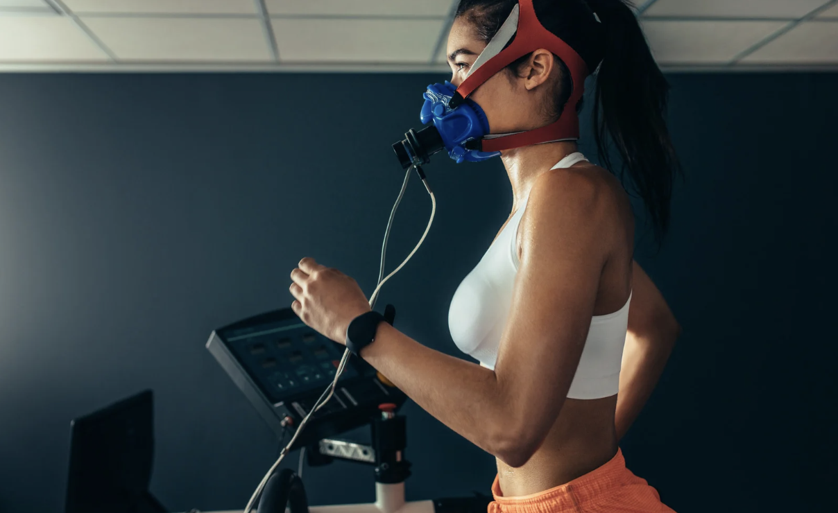 Athlete running on a treadmill wearing a VO₂ max testing mask.